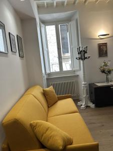 a living room with a yellow couch and a window at Ver Sacrum - Appartamento in centro in Ascoli Piceno +23 photos