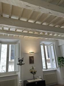 a room with two windows and a wooden ceiling at Ver Sacrum - Appartamento in centro in Ascoli Piceno