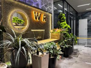 a store with potted plants and a sign on a wall at Wind Rose in Almaty