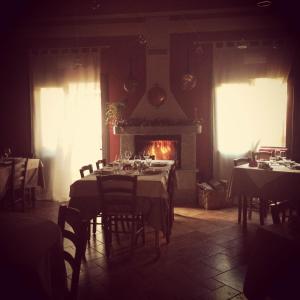 una sala da pranzo con tavoli e camino di I Malpensanti del Trieste a Monticelli dʼOngina