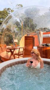 a woman sitting in a hot tub with a glass of wine at Sora Bubble in Angelina