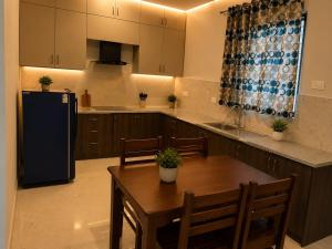 a kitchen with a wooden table and a refrigerator at sea stay inn in Mahabalipuram