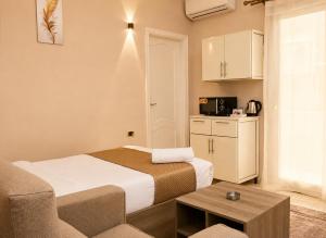 a small hotel room with a bed and a table at Roadhouse New Cairo Residence in Cairo