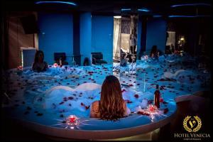 a woman sitting in a bath tub in a room at Hotel Venecia ll in Huánuco