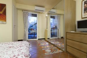 1 dormitorio con 1 cama, TV y espejo en Camera Dolcenotte, en Orta San Giulio
