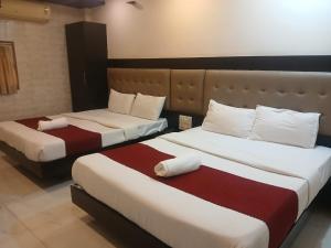 a hotel room with two beds in a room at Hotel Bkc Palace Kurla in Mumbai