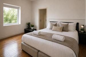 a bedroom with a large white bed with a window at NUJU Rentals - 4-Zimmer, 10 Gäste, Wintergarten & Terrasse & Parkplatz in Bielefeld