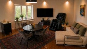 a living room with a couch and a table at NUJU Rentals - 4-Zimmer, 10 Gäste, Wintergarten & Terrasse & Parkplatz in Bielefeld