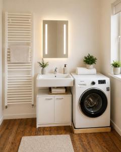 a bathroom with a washing machine and a sink at NUJU Rentals - 4-Zimmer, 10 Gäste, Wintergarten & Terrasse & Parkplatz in Bielefeld +5 photos