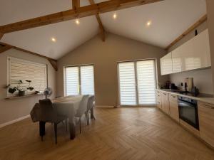 a kitchen with a table and chairs in a room at Chill and Grill Apartments in Wola Smolana