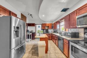 a kitchen with wooden cabinets and a stainless steel refrigerator at Stay with Jay - Quinta Suite in Cleveland