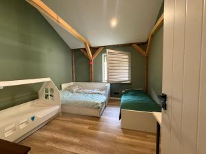 a small bedroom with a bed and a tub at Chill and Grill Apartments in Wola Smolana