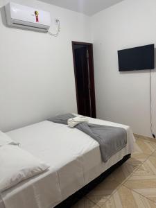 a bedroom with a bed and a flat screen tv at Hotel Ipê Centro in Barreirinhas