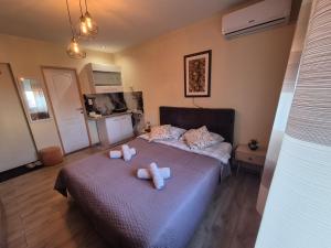 a bedroom with a bed with two stuffed animals on it at Grey Apartments Zaječar in Zaječar