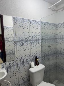 a bathroom with a toilet and a glass shower at Hotel Ipê Centro in Barreirinhas