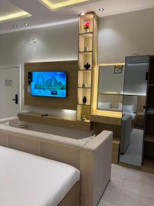 a room with a tv on a wall with a couch at لين سويت in Khamis Mushayt