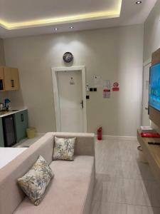 a living room with a couch and a clock on the wall at لين سويت in Khamis Mushayt