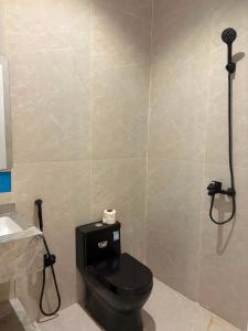 a bathroom with a black toilet and a shower at لين سويت in Khamis Mushayt