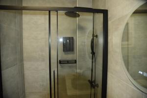 a glass shower in a bathroom with a mirror at Luxury Green Apartment in Serres +40 photos