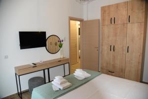 a bedroom with a desk and a bed with towels at Luxury Green Apartment in Serres