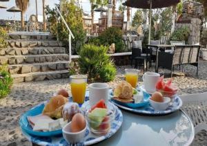 a table with two plates of food and orange juice at Santa Elena in Kamari