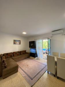 a living room with a couch and a table at Iljon Apartments in Tushemisht