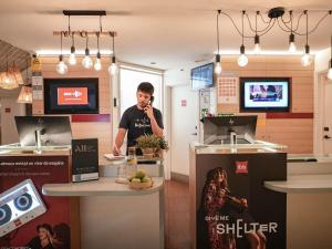 a man talking on a cell phone in a kitchen at ibis Porto Centro São Bento in Porto