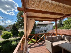 a patio with a couch and a wooden deck at Apartmani Dora in Mataruška Banja