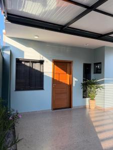 a house with a wooden door in a building at Bairro Universtário - Central in Cascavel