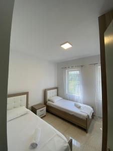 a bedroom with two beds and a window at Iljon Apartments in Tushemisht