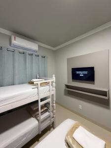 a hospital room with a bed and a tv at Bairro Universtário - Central in Cascavel