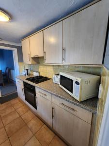 a kitchen with a microwave and a stove at The Iris in Grays Thurrock