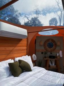 a bedroom with a bed and a large window at Sora Bubble in Angelina