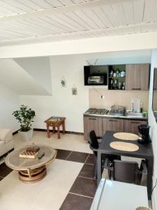 a living room with a table and a kitchen at Cabaña con Jacuzzi Privado en El Peñol El palmar lodge in Chiquinquirá
