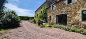 a dirt road next to a stone building at Manoir des Nobles Cœurs et Spa in Saint-Donan