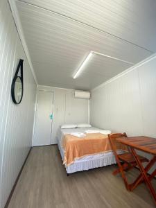 a room with a bed and a table in it at Pousada Villa Sítio in Campina Grande