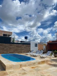 a swimming pool with lounge chairs next to a building at Pousada Villa Sítio in Campina Grande
