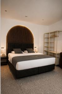 a bedroom with a large bed with a large headboard at Valverda - Boutique Apartments in Grödig