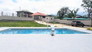 a swimming pool in front of a house at Solace Guest house in Buea