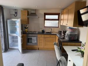 a kitchen with wooden cabinets and a white refrigerator at Self contained Coventry in Coventry