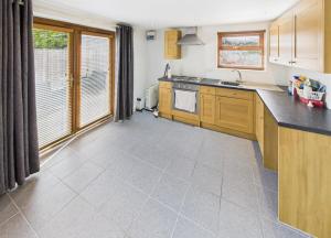 a kitchen with wooden cabinets and a tile floor at Self contained Coventry in Coventry