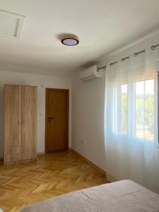 a room with a bed and a window and a door at Apartmani Dora in Mataruška Banja