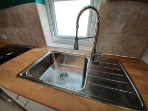 a stainless steel sink in a kitchen with a window at The Moonflower in Grays Thurrock +96 photos