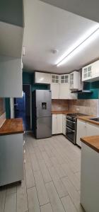 a large kitchen with white cabinets and appliances at The Moonflower in Grays Thurrock