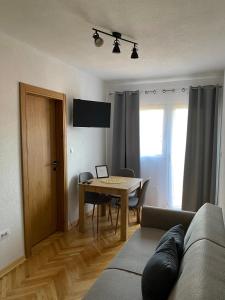 a living room with a couch and a dining room table at Apartmani Dora in Mataruška Banja