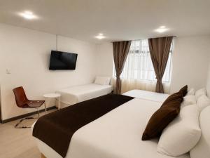 a hotel room with a bed and a tv at Zentio Hotel in Bogotá
