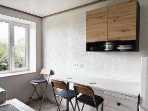 a kitchen with a white counter and three chairs at Voore Korterid in Ohukotsu