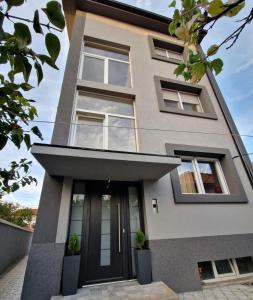 a house with a black door and windows at Grey Apartments Zaječar in Zaječar +4 photos