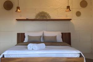 a bedroom with a bed with two towels on it at Villa Dolce Mare in Arraial do Cabo