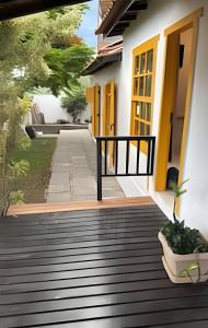 a wooden walkway leading to a building with yellow doors at Villa Dolce Mare in Arraial do Cabo